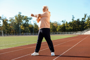 Obraz premium Sporty senior man training at stadium