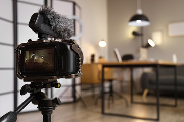 Interior of recording studio with workplace, sofa and glowing lamps on camera screen, closeup