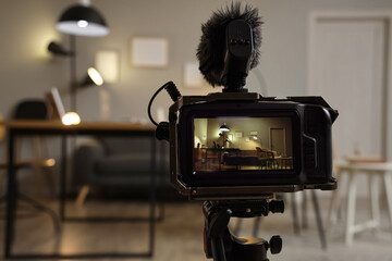 Interior of recording studio with workplace, sofa and glowing lamps on camera screen, closeup
