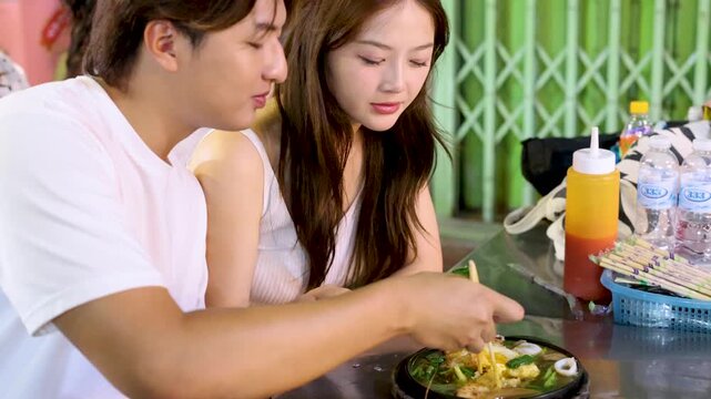 Young Couple Sharing Noodles at Bangkok Street Food Stall