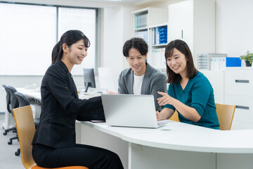 若い夫婦と商談をするセールスマン