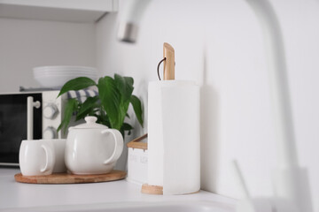 Roll of paper towels and tea set on counter in kitchen