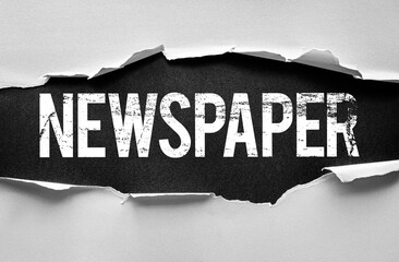 Word NEWSPAPER revealed behind torn paper. Conceptual image symbolizing traditional print journalism, daily news, headlines, articles, publishing, media, and information dissemination