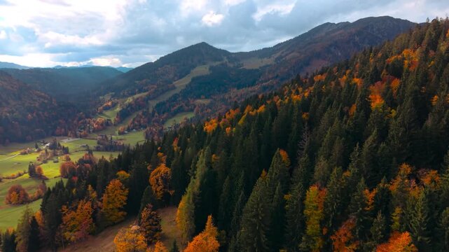 Drone view over Heutal hillsides with dense colorful autumn forest and rugged alpine landscape.