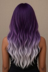 Fototapeta premium A back view of a person with long, wavy hair that has a beautiful purple and white ombre color transition.