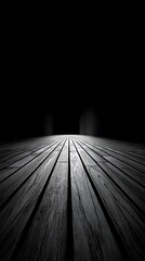 Dark wooden floorboards bathed in a bright spotlight on a black stage