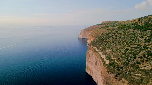 Epic aerial 4K view of Dingli Cliffs at sunset, high limestone precipice over the Mediterranean sea, scenic coastal landscape of Malta island, drone shot