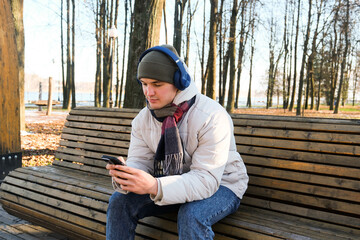 Man enjoying music on smartphone in autumn park
