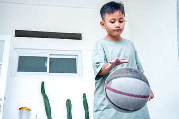 Young Asian Boy Wearing Sage Green T-Shirt Dribbling Basketball With One Hand
