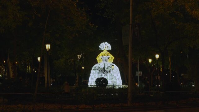 Spain, Madrid - November 27,  2025:  Luminous Menina sculpture glowing in Madrid park