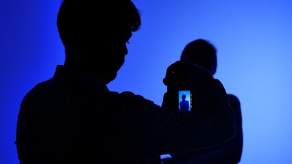 Backstage Silhouette of Photographer Shooting Model in Blue Light