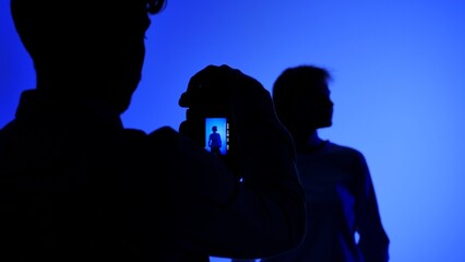 Backstage Silhouette of Photographer Shooting Model in Blue Light