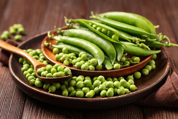 Plates with fresh green peas on wooden background, closeup