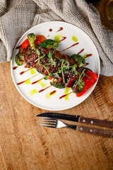 Grilled steak with vegetables served on a white plate