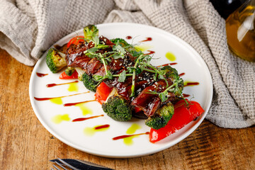 Grilled meat served with vegetables on a white plate