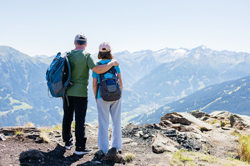 Hikers embracing majestic mountain vista: father and daughter sharing a special moment in nature