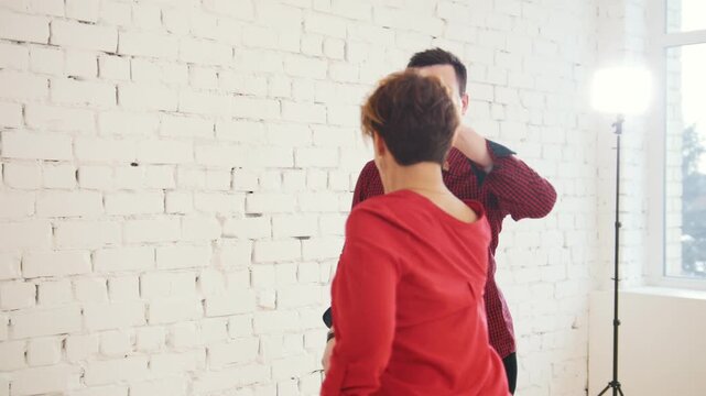 Family couple - male and female is dancing kizomba in white studio near window