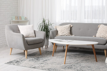 Interior of modern room with comfortable armchair and sofa