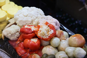 Red pepper stuffed with sauerkraut prepared on grill at a Christmas market where various traditional dishes are served.