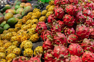 Close-up photo of pink and yellow pitahaya (dragon fruit) in supermarket display in Sanya, Hainan, China. Colorful tropical produce in a Sanya supermarket, exotic freshness and local food culture.