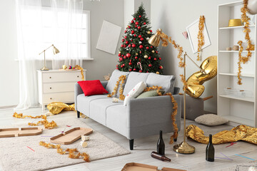 Interior of messy living room with sofa and tinsel after New Year party