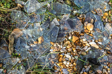 Broken glass amongst the pebbles on a beach