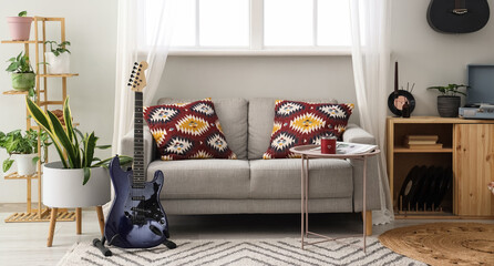 Interior of living room with sofa, guitars and plants