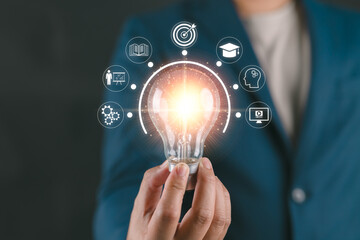 Businessman holding a glowing lightbulb with learning icons, symbolizing knowledge, creative thinking, innovation, and problem-solving solutions.