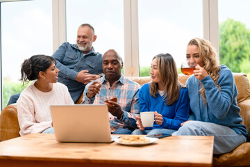 Friends sharing stories while enjoying drinks and snacks at a cozy indoor setting in the afternoon