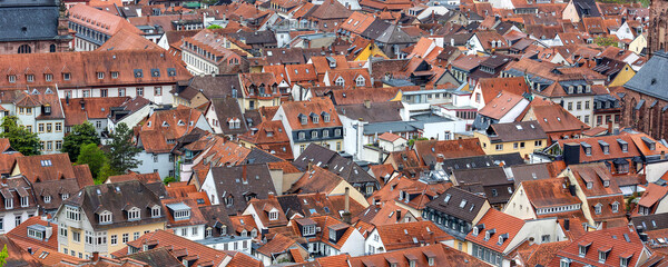 Scenic aerial view patchwork of Heidelberg red rooftops tiled roofs historical colorful houses medieval old city German Baden-Wurttemberg. Abstract texture charm historic old town architecture