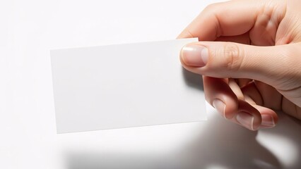 Obraz premium Hand holding a blank white business card isolated on white background