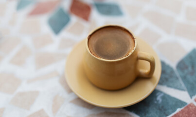 Close-up of small cup of coffee on table.