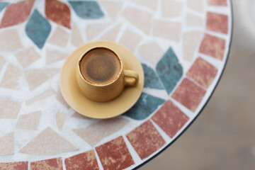 Close-up of small cup of coffee on table.
