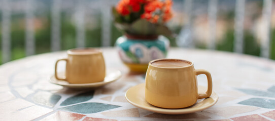 Close-up of two small cups of coffee on table. Panoramic photo.