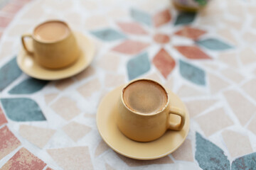 Close-up top view of two small cups of coffee on table.