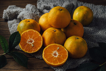 Fresh Oranges on Wooden Table with Green Leaves and Texture Background