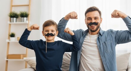 Father and son in casual wear with mustache props flex muscles while posing in a bright living room