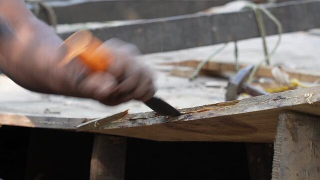 person using a chisel and a mallet to work on a piece of wood
