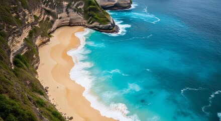Aerial view of a dramatic coastline with people on the beach and cliffs in Indonesia. A landscape of coastal cliffs overlooking a clear blue ocean on a sunny day.