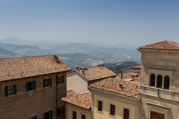 Buildings of old city on background of Italian fields. Old roof.