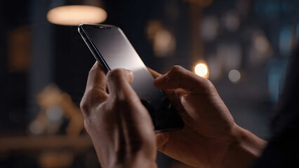 Hands gripping a mobile phone in a close-up shot, lit naturally with a gentle background blur, showing modern communication, digital habits, and daily smartphone interaction.