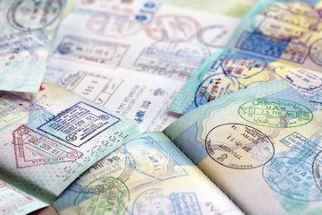 Many open passport pages with lots of visas and entrance stamps from various countries passport control. Concept of travel and tourism worldwide
