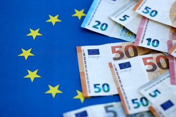Many euro money bills banknotes on flag of European Union. Concept of business and finances in Europe