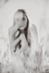 Young woman in rye field with soft-focus and monochrome tones