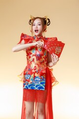 Happy Asian Woman Holding Red Envelopes and Fan. Fashionable female model in Modern Qipao with Ang Pao.