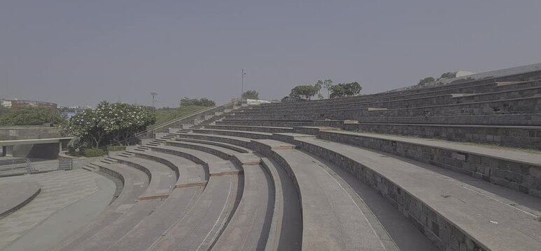 Wide-angle view of the modern stone-stepped amphitheatre and outdoor seating area at Dilli Haat,  Delhi