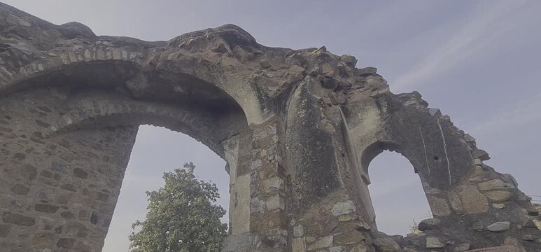 Medieval Stone Archways and Weathered Rubble Walls of the 14th-Century Jami Masjid Ruins within the Feroz Shah Kotla Fort Complex in New Delhi India
