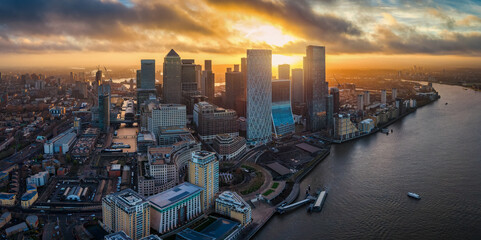 Panoramic aerial view of the residential and financial office skyscrapers at Canary Wharf and the Docklands in London, England, during sunrise