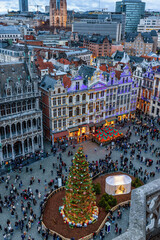 Elevated view of the Grand Place or Grote Market in Brussels, Belgium, during Christmas time with a decorated tree and tourists enjoying the square