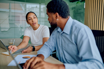 Obraz premium Diverse business professionals discussing work, analyzing data, and brainstorming ideas during a meeting in a contemporary workspace
